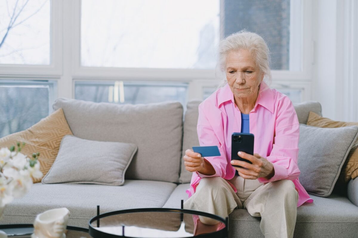 Senior woman using a smartphone at home on the couch